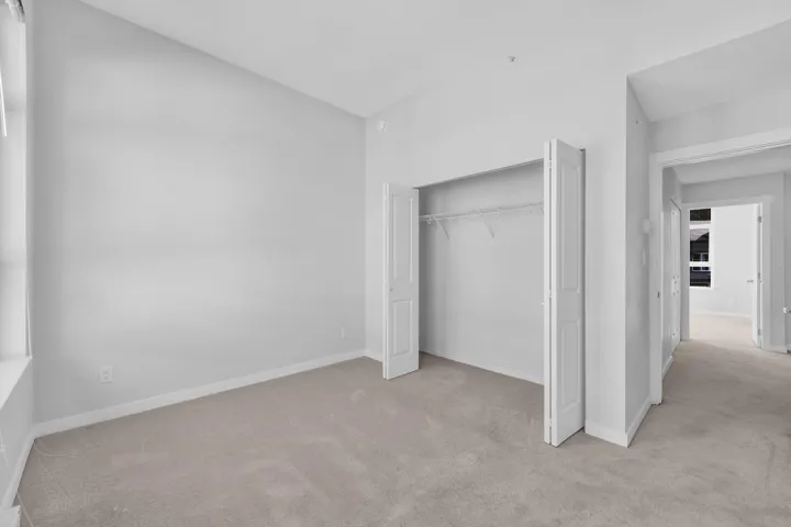 Recessed ceiling lighting, wood-finish flooring, multiple windows, track lighting, and a partial wall