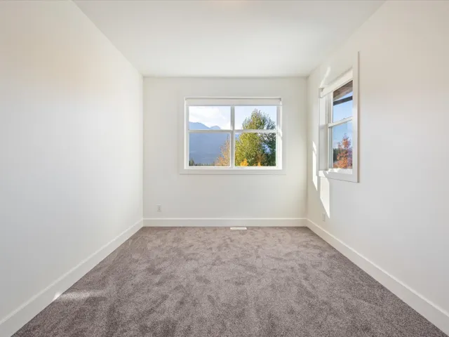 Spare room with light carpet and baseboards