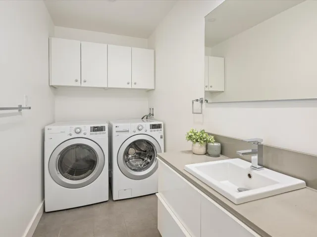 Washroom featuring cabinet space, washing machine and clothes dryer, and tile patterned floors