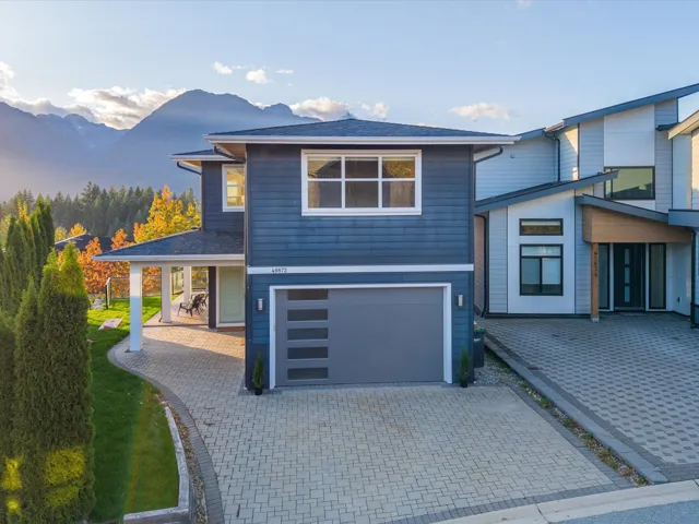 View of front of house featuring a garage, a mountain view, decorative driveway, and a patio
