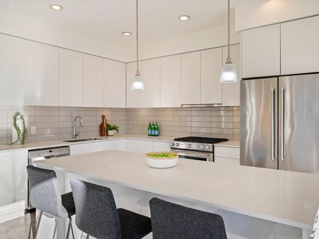 Kitchen featuring appliances with stainless steel finishes, tasteful backsplash, hanging light fixtures, white cabinets, and recessed lighting