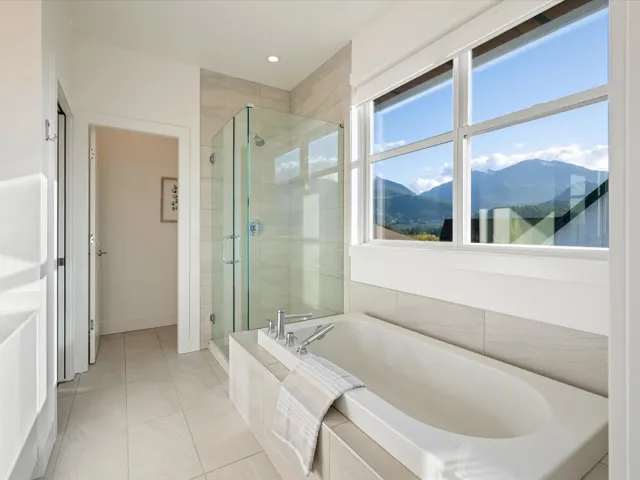 Full bath featuring a mountain view, a garden tub, light tile patterned floors, and a shower stall