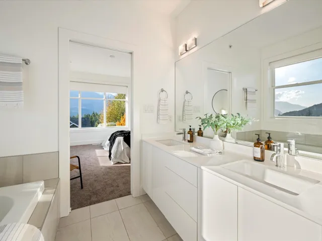 Bathroom with light tile patterned floors, double vanity, plenty of natural light, and a bath