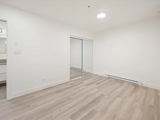 Unfurnished bedroom featuring baseboard heating, light wood-style floors, and a closet