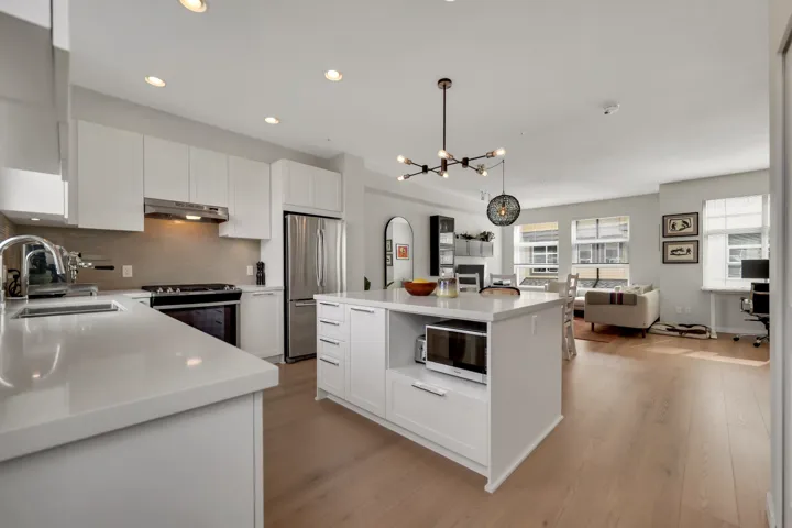 Kitchen with a kitchen island, stainless steel appliances, white cabinets, and light wood-style flooring