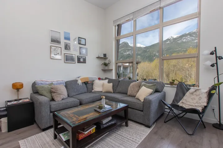 Living room with wood finished floors, a high ceiling, and a mountain view