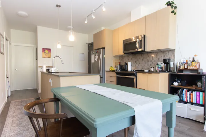 Kitchen featuring dark wood finished floors, light brown cabinets, appliances with stainless steel finishes, and a sink