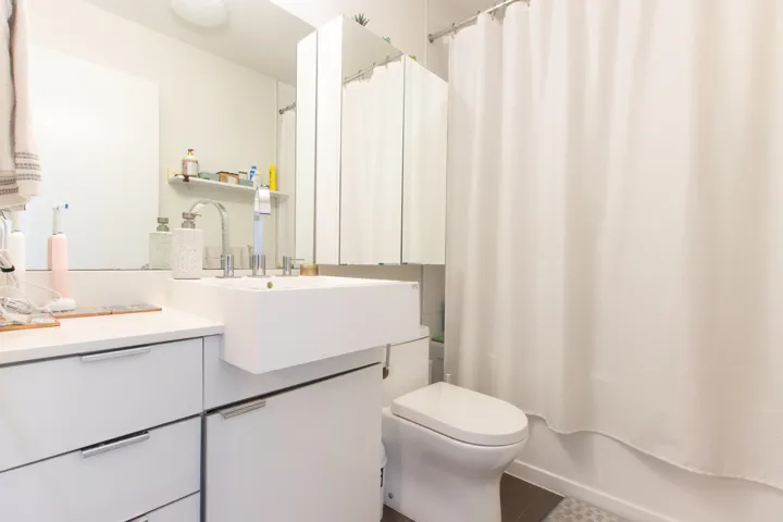 Bathroom featuring tile patterned floors, shower / bath combo, vanity, and toilet