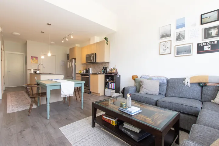 Living area with light wood-style flooring and rail lighting