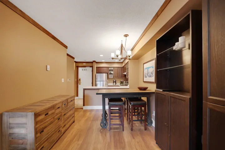 Dining space with crown molding, hanging lights, and light wood-style flooring