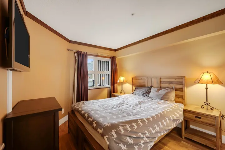 Bedroom with wood finished floors and ornamental molding