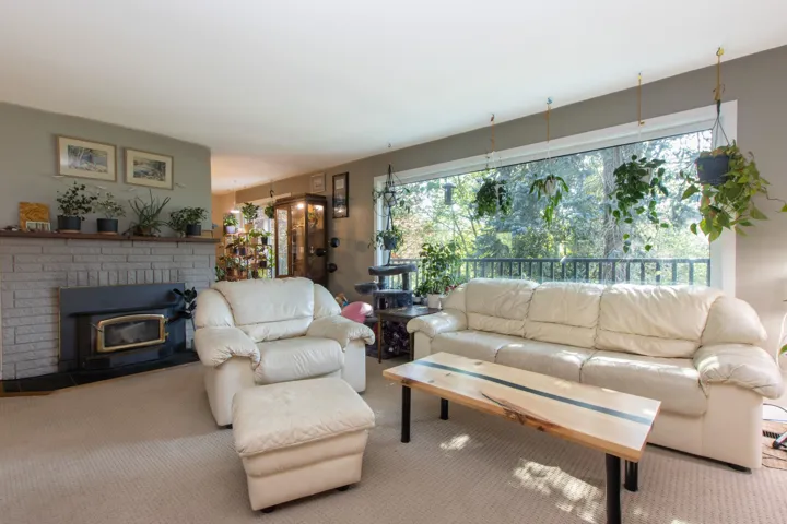 Carpeted living area with a brick fireplace and a healthy amount of sunlight