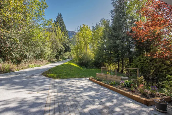 View of community featuring a yard, a vegetable garden, and a forest view