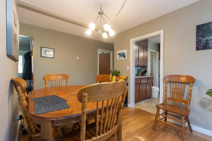 Dining room with a chandelier, baseboards, and light wood-type flooring