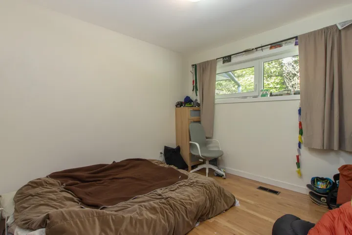 Bedroom with visible vents, wood finished floors, and baseboards