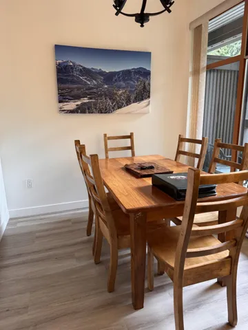 Dining area featuring a notable chandelier, baseboards, and wood finished floors
