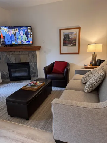 Living area with a tiled fireplace and wood finished floors