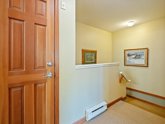 Hallway with a baseboard radiator and an upstairs landing