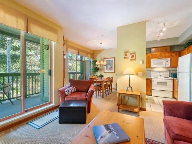 Living area with a chandelier, light carpet, and light tile patterned floors