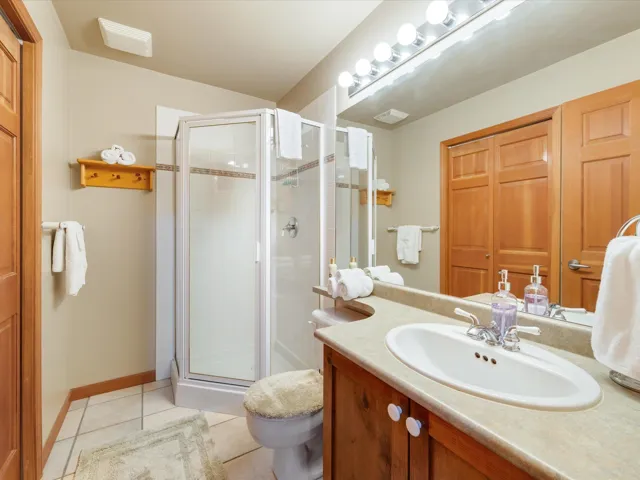 Full bathroom featuring a stall shower, vanity, and tile patterned flooring