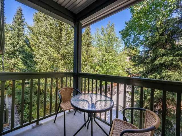 Balcony featuring a wooded view
