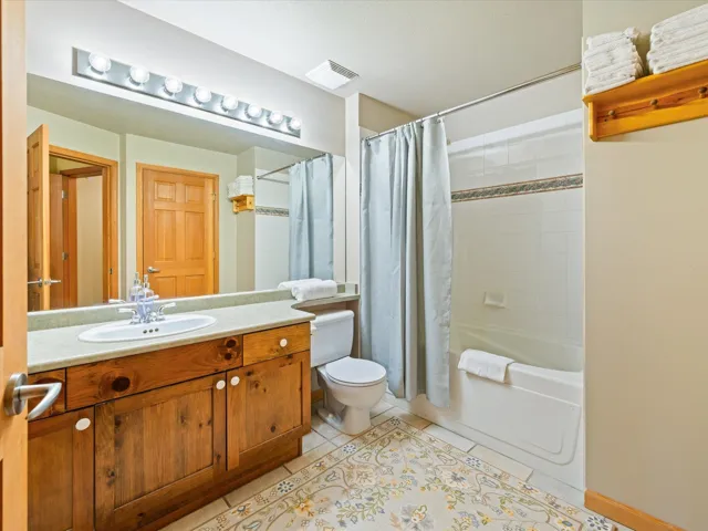 Full bathroom featuring vanity, shower / tub combo, and tile patterned flooring