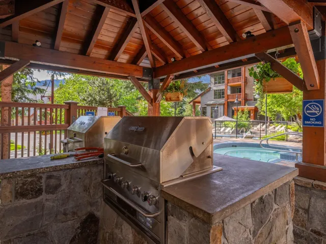 View of patio with area for grilling and a pool
