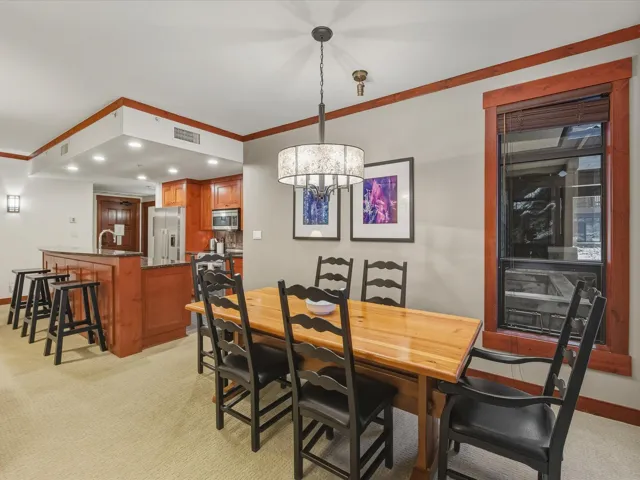 Dining space featuring light colored carpet, crown molding, a chandelier, and recessed lighting