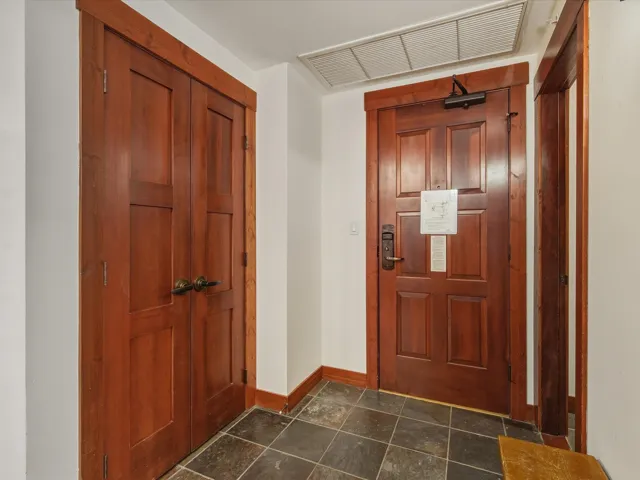 Foyer entrance with baseboards and stone tile flooring