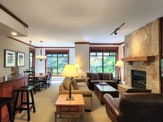 Living room featuring a fireplace, ornamental molding, a chandelier, and recessed lighting