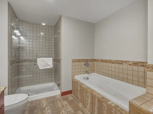 Full bath with a whirlpool tub, vanity, a shower stall, and recessed lighting