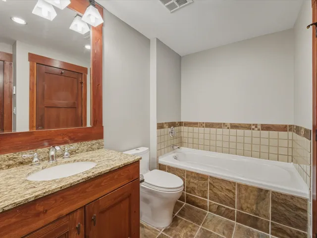Full bath with a garden tub and vanity
