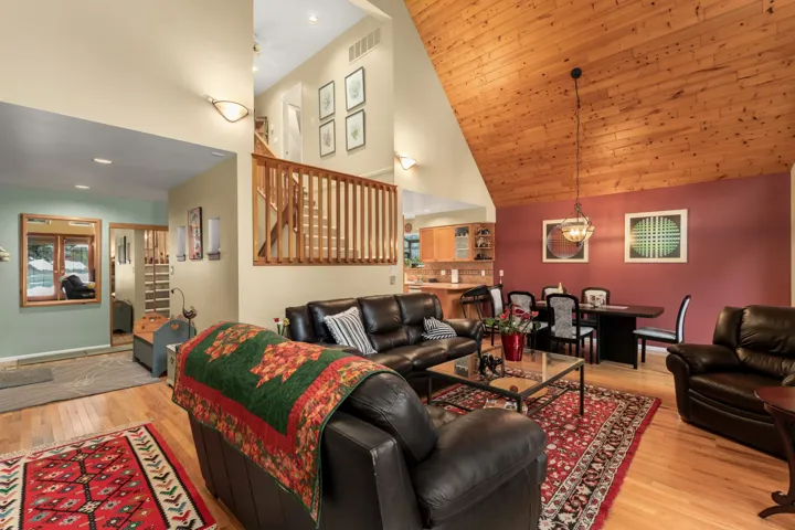Living area featuring light wood-style flooring and a vaulted wood ceiling