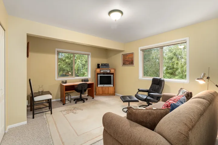 Main Floor Bedroom / Family Room / Office space with light colored carpet and baseboards