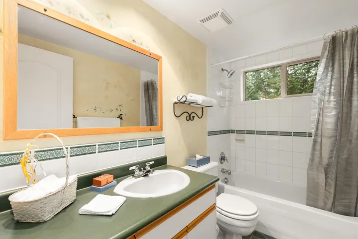 Main Floor Full bath featuring shower / bath combination with curtain, vanity, and decorative backsplash