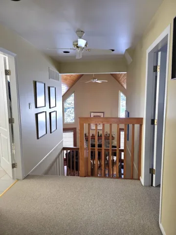 Corridor featuring carpet floors and vaulted ceiling