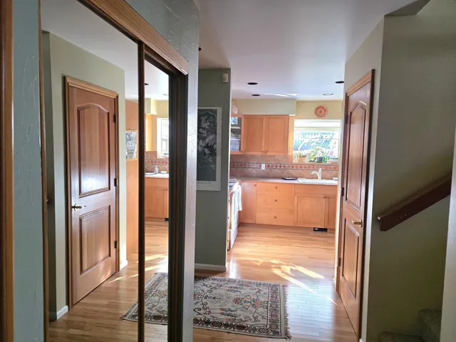 Corridor with light wood finished floors and view to kitchen