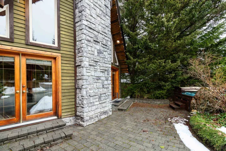 View of exterior front featuring French doors, a patio area with a hot tub