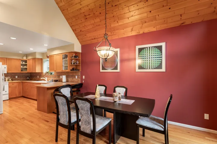 Dining room with light wood-style floors, a vaulted wooden ceiling, and recessed lighting