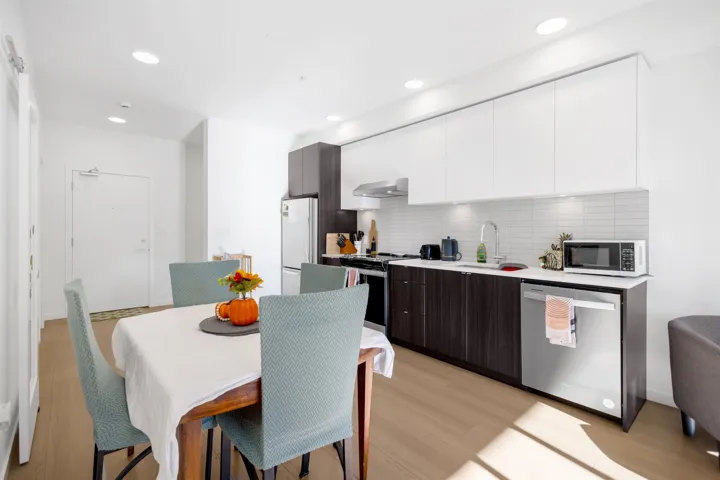 Dual tone kitchen featuring dual tone cabinets, modern cabinets, stainless steel appliances, light wood finished floors, and recessed lighting
