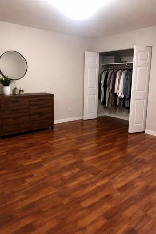 Unfurnished bedroom with dark wood-type flooring and a closet