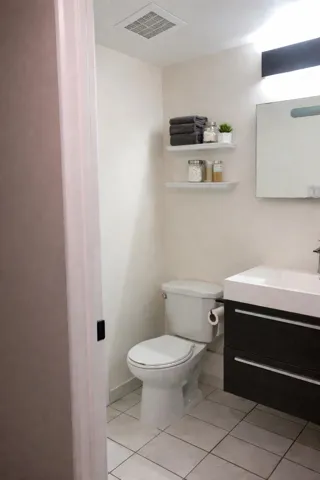 Half bathroom featuring vanity and light tile patterned flooring