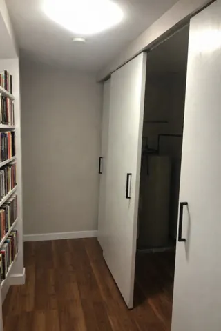Hallway featuring dark wood-type flooring and baseboards
