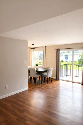 Dining area with dark wood-style floors and baseboards