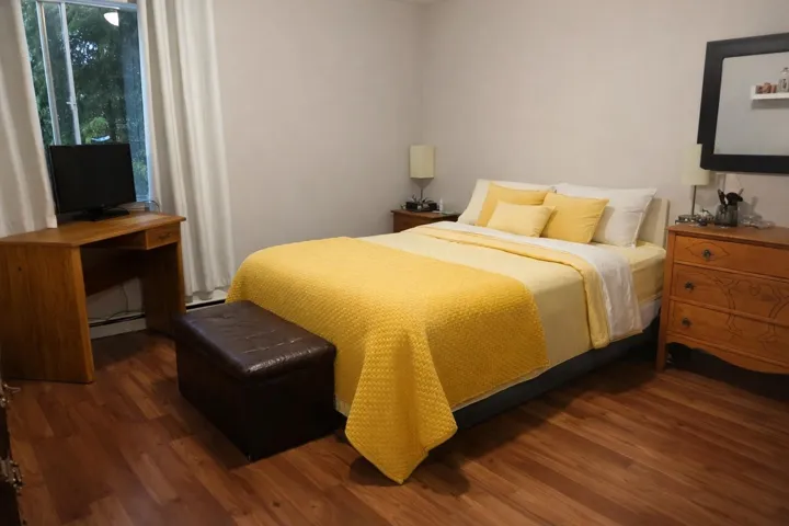Bedroom with dark wood-type flooring and a baseboard radiator