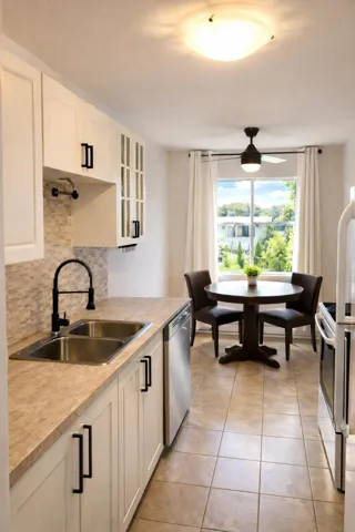 Kitchen featuring white cabinetry, glass insert cabinets, light countertops, range with electric cooktop, and light tile patterned flooring