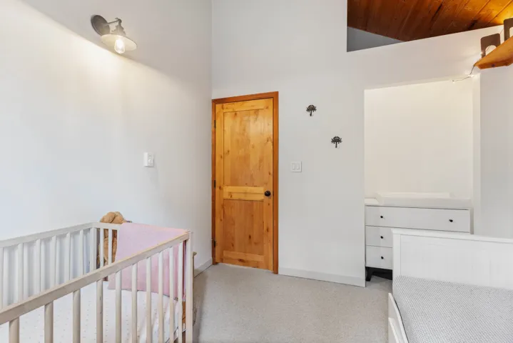 Bedroom with wooden ceiling, light carpet, baseboards, and vaulted ceiling