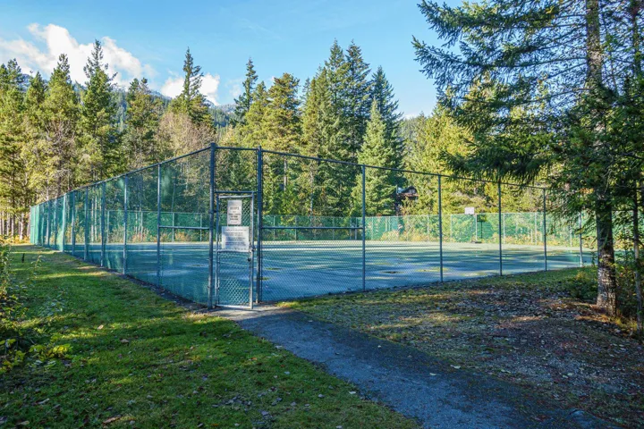 View of sport court featuring a lawn, a gate, fence, and community basketball court