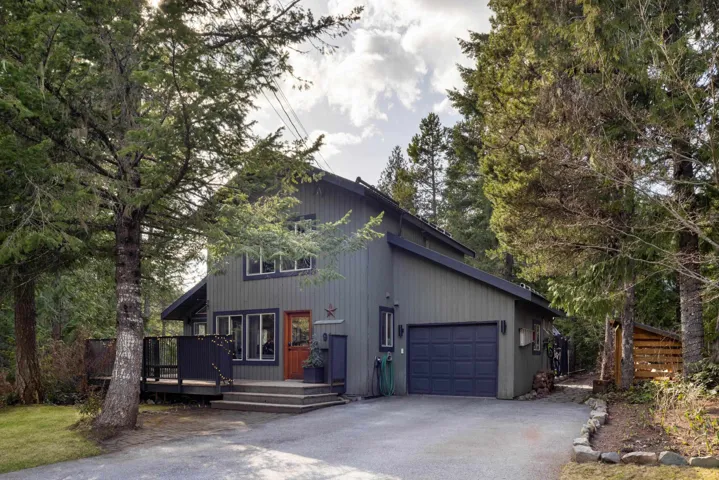 Rustic home featuring driveway, a wooden deck, and a garage