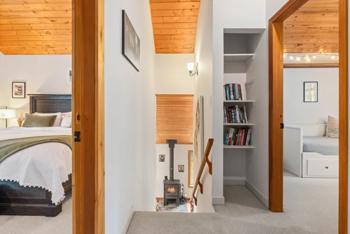 Interior space featuring baseboards, vaulted ceiling, wooden ceiling, and carpet flooring